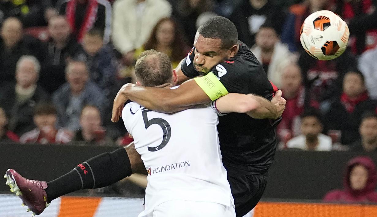 Pemain Bayer Leverkusen, Jonathan Tah, berebut bola dengan pemain West Ham United, Vladimir Coufal, pada laga Perempat final Liga Europa di Stadion BayArena, Jumat (12/4/2024). (AP Photo/Martin Meissner)