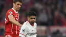 Pemain Bayern Munchen, Thomas Mueller berebut bola dengan pemain Sevilla, Ever Banega pada laga leg kedua perempat final Liga Champions di Allianz Arena, Kamis (12/4). Bayern Munchen melangkah ke semifinal usai bermain tanpa gol. (Christof STACHE/AFP)