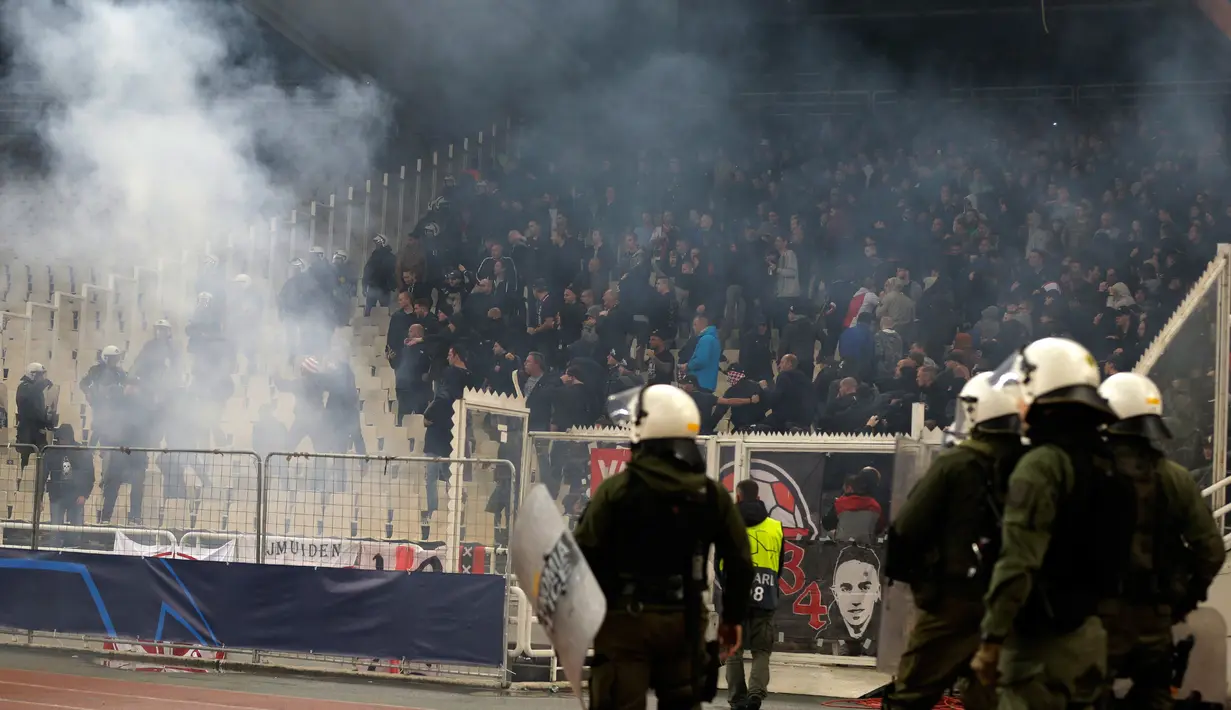 Kepulan asap flare terlihat sebelum pertandingan Liga Champions antara Ajax Amsterdam melawan AEK Athena di Stadion Olimpiade Athena, Selasa (27/11). Suporter tuan rumah melempar flare dan bom molotov ke arah tribun suporter Ajax. (AP/Thanassis Stavrakis)