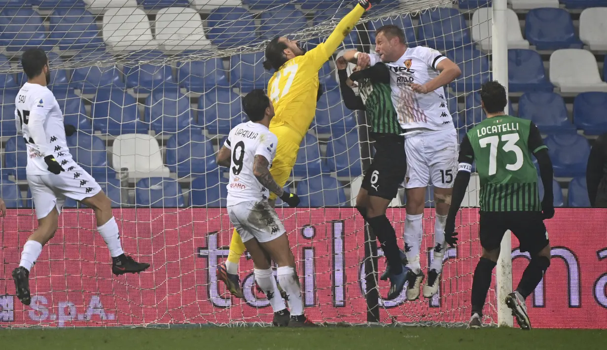 Kiper Sassuolo, Andrea Consigli berusaha menghalau bola sundulan bek Benevento, Kamil Glik pada pertandingan lanjutan Liga Serie A Italia di Stadion Mapei di Reggio Emilia, Italia, Sabtu (12/12/2020). Dengan kemenangan ini, Sassuolo naik ke peringkat dua klasemen. (Massimo Paolone/LaPresse via AP)