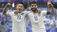 Selebrasi striker Timnas Uzbekistan, Abbosbek Fayzullaev (kiri) bersama kapten tim, Jaloliddin Masharipov setelah mencetak gol kedua ke gawang Thailand pada laga babak 16 besar Piala Asia 2023 di Al Janoub Stadium, Al Wakrah, Qatar, Selasa (30/1/2024). (AP Photo/Hussein Sayed)