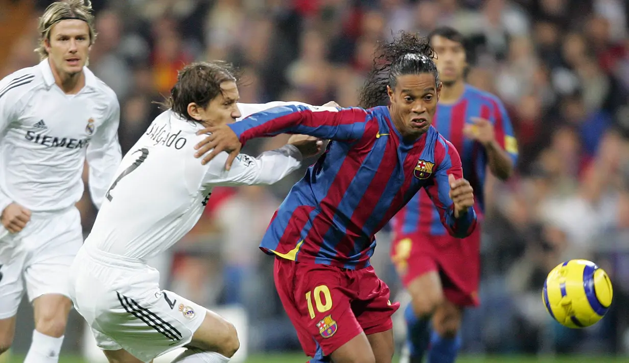 Ronaldinho mengelabui Michel Salgado dalam laga El Clasico di Stadion Santiago Bernabeu, Madrid, (19/11/2005). Ronaldinho mencetak dua dari tiga gol kemenangan Barcelona. (AFP Photo/Javier Soriano)