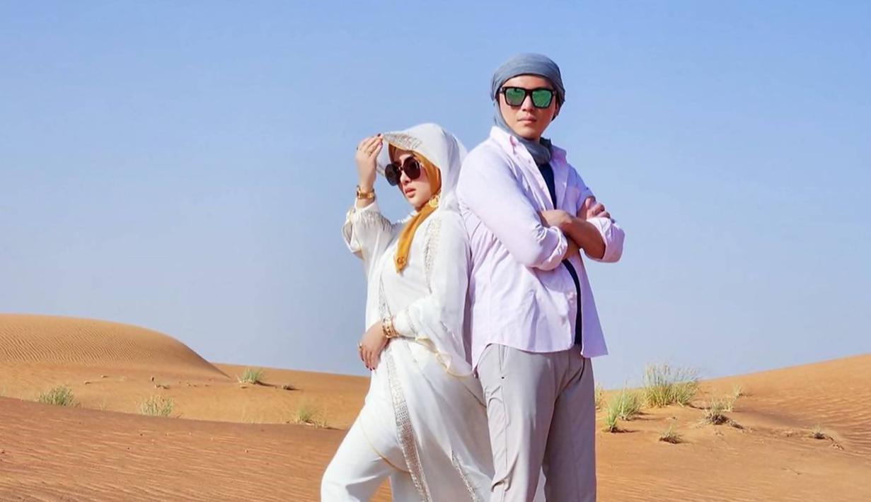 Beberapa waktu belakangan ini, selebriti yang tengah menikmati momen liburan ke gurun pasir ialah Syahrini bersama suaminya, Reino Barack. Dalam liburannya ke Dubai ini keduanya abadikan momen mesra saat berada di padang gurun. Tampil serasi dengan busana serba putih, pasangan ini menuai banyak pujian. (Liputan6.com/IG/princessyahrini)