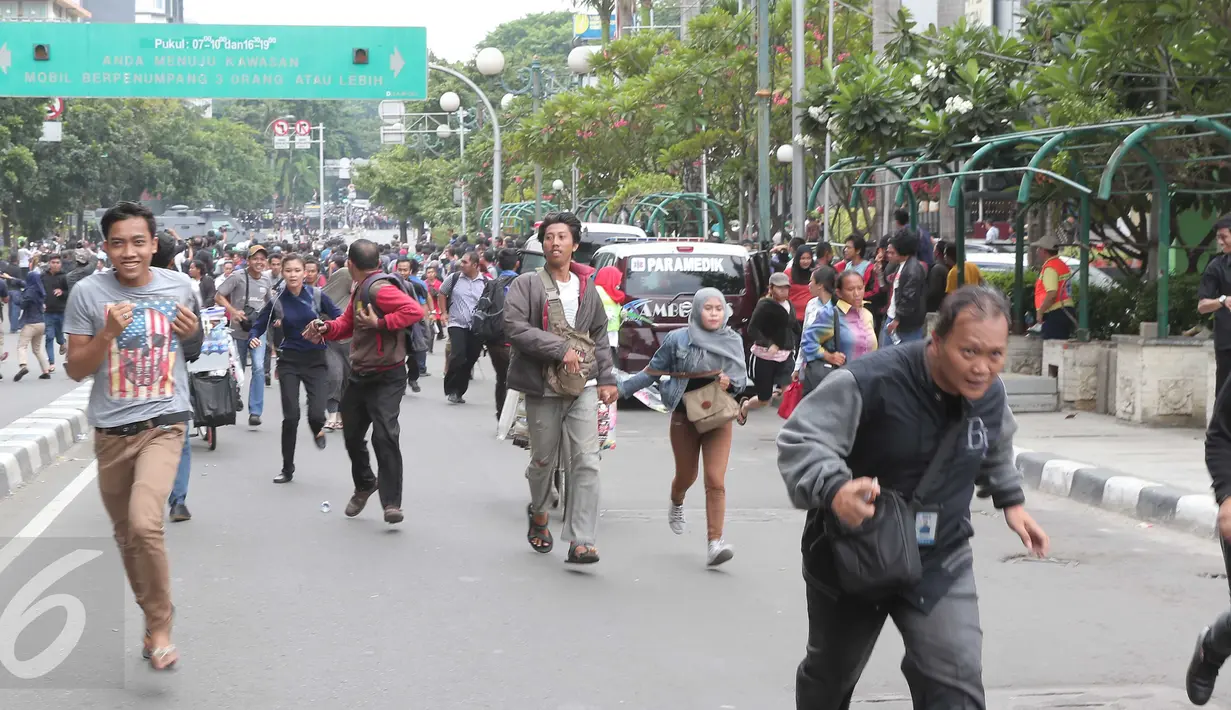Seorang jurnalis (kanan) bersama sejumlah warga berlarian usai mendengar isu bom yang akan kembali meledak pasca ledakan yang terjadi di Pos polisi dekat pusat perbelanjaan Sarinah, Jalan Thamrin, Jakarta, Kamis (14/1). (Liputan6.com/Angga Yuniar)