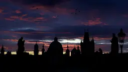 Matahari terbit di atas Jembatan Charles yang dibangun pada abad pertengahan di Praha, Republik Ceko, Kamis (8/10/2020). Ceko adalah salah satu negara terparah di Eropa Tengah dan Timur yang mengkonfirmasi lonjakan rekor infeksi COVID-19 selama beberapa pekan terakhir. (AP Photo/Petr David Josek)