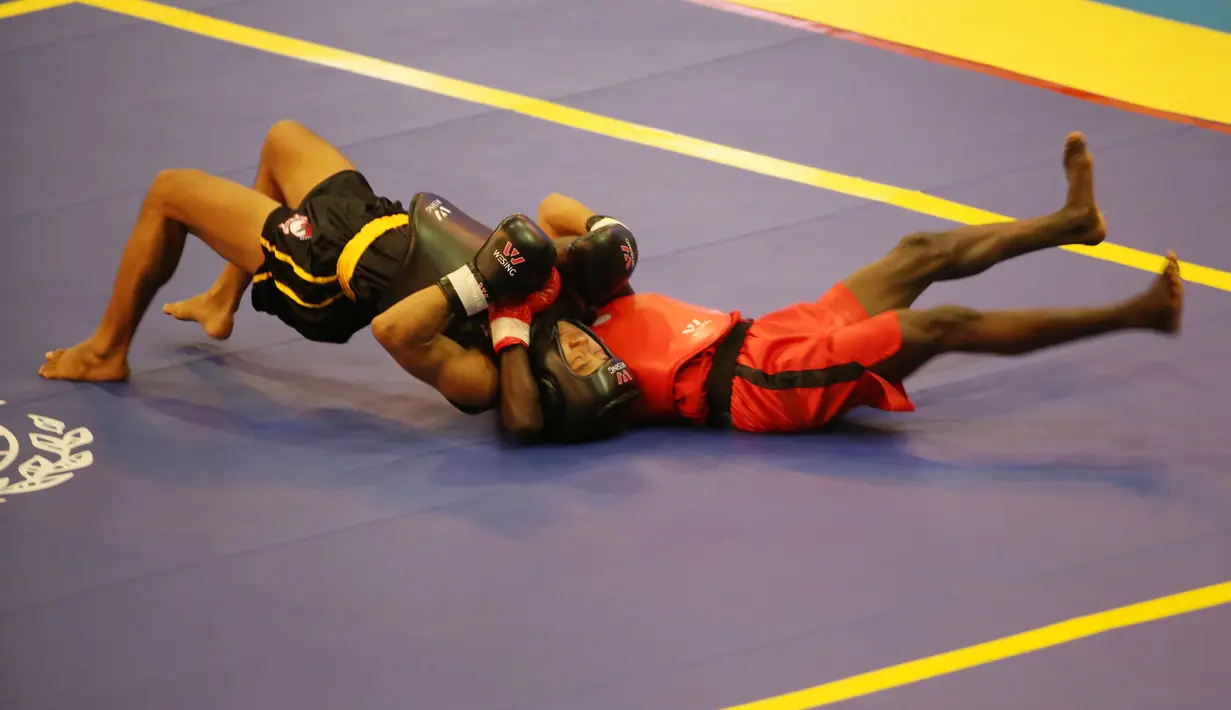 Atlet Wushu Indonesia, Yusuf Widiyanto (kiri) membanting lawannya asal Pantai Gading, Mohamed Doumbia, pada Kejuaraan Dunia Wushu 2015 di Istora Senayan, Jakarta, Minggu(15/11/2015). (Bola.com/Nicklas Hanoatubun)