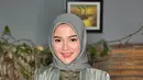 Ia menyempurnakan penampilannya dengan hijab warna hijau sage. Wajahnya pun dipoles dengan makeup natural.