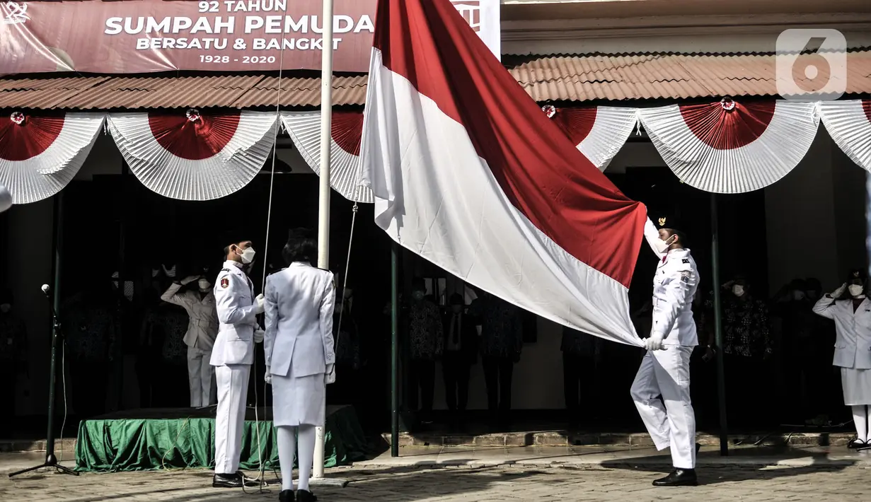 Tim Paskibra mengibarkan bendera Merah Putih upacara peringatan Sumpah Pemuda di Museum Sumpah Pemuda, Jakarta, Rabu (28/10/2020). Upacara peringatan 92 tahun Sumpah Pemuda yang mengangkat tema Sumpah Pemuda Bersatu dan Bangkit tersebut diadakan secara terbatas. (merdeka.com/Iqbal S Nugroho)