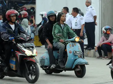Pemudik menggunakan Vespa keluaran tahun 60 an saat masuk ke dalam kapal penyeberangan di Pelabuhan Merak, Banten, Jumat (23/6). H-2 Lebaran 2017, ribuan pemudik bermotor memadati dermaga 6 Pelabuhan Banten. (Liputan6.com/Helmi Fithriansyah)