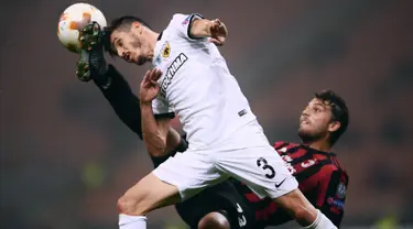 Bek AEK Athens, Helder Lopes melompat merebut bola dari gelandang AC Milan, Manuel Locatelli pada pertandingan Grup D Liga Europa di San Siro, Kamis (19/10). AEK Athens menambah kekecewaan AC Milan setelah hanya bermain tanpa gol. (MARCO BERTORELLO/AFP)