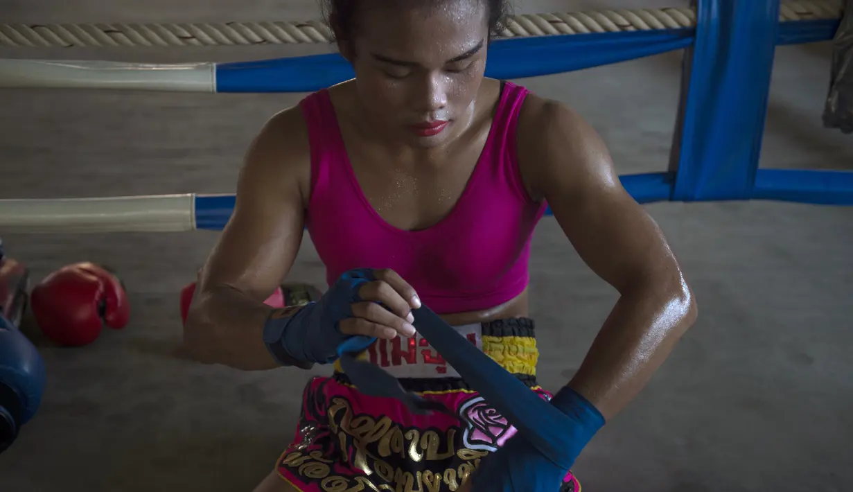 Petinju Muay Thai Nong Rose beristirahat di sela latihannya di provinsi Chachoengsao, Thailand (15/12). Setelah lebih dari 300 pertarungan, Nong Rose berlatih untuk mempersiapkan pertandingannya di Prancis. (AFP Photo)