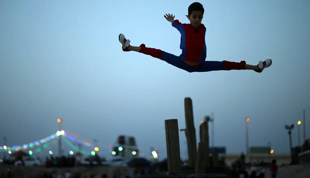 Aksi akrobat Mohammed al Sheikh melompat ke atas, di sebuah pantai di Kota Gaza, Palestina, Kamis (2/6). Remaja 12 tahun itu menyatakan keinginannya untuk mencetak rekor dunia Guinness World Record yang baru. (REUTERS/Mohammed Salem)