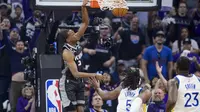 Pemain Sacramento Kings De'Aaron Fox melakukan dunk saat melawan Warriors di play-off NBA 2023 (AP)