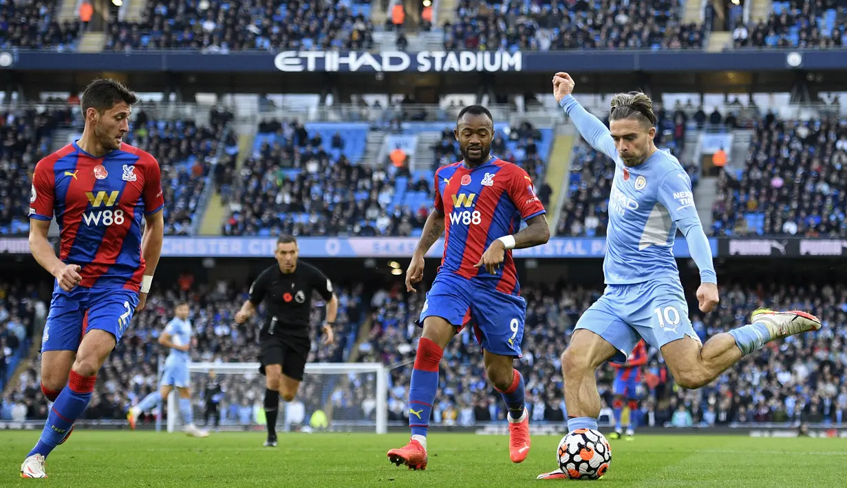 Pemain Manchester City Jack Grealish (kanan) menendang bola di depan pemain Crystal Palace pada pertandingan Liga Inggris di Etihad Stadium, Manchester, Inggris, 30 Oktober 2021. Crystal Palace menang 2-0. (Oli SCARFF/AFP)