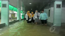 Petugas rumah sakit melintasi banjir yang menggenangi RS Islam Jakarta, Senin (9/2/2015). (Liputan6.com/Herman Zakharia)