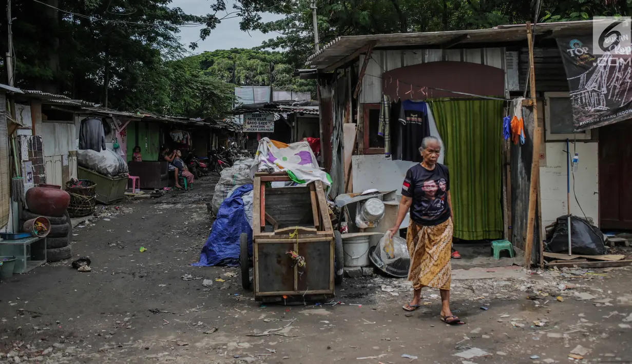 Warga berjalan di permukiman liar di kawasan Bypass, Pramuka, Jakarta Timur, Rabu (21/2). Rencana Pemprov DKI untuk membangun kantor pemadam kebakaran di lokasi tersebut terkendala oleh bangunan liar yang diduduki pemulung. (Liputan6.com/Faizal Fanani)