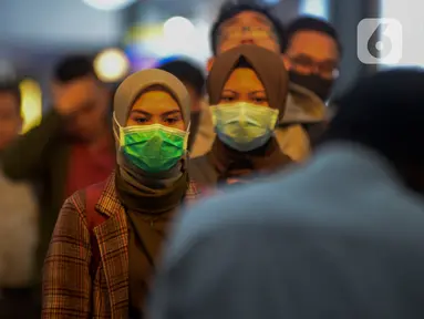 Calon penumpang kereta api mengenakan masker saat berada di Stasiun Gambir, Jakarta Pusat, Jumat (31/01). Dalam rangka pencegahan Virus Corona, PT Kereta Api Indonesia (persero) melakukan sosialisasi kepada penumpang dengan membagi-bagikan masker di stasiun Gambir. (merdeka.com/Imam Buhori)