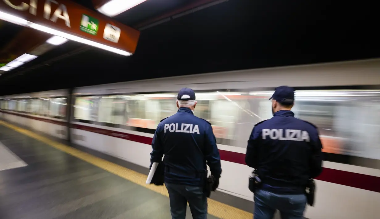 Polisi menunggu di peron untuk memeriksa kartu kesehatan Covid-19 penumpang saat pemberlakuan ‘Super Green Pass’ di Roma, Senin (6/12/2021). Polisi Italia dapat memeriksa apakah pengunjung memiliki Green Pass yang menunjukkan bukti vaksinasi atau kesembuhan dari virus. (AP/Andrew Medichini)