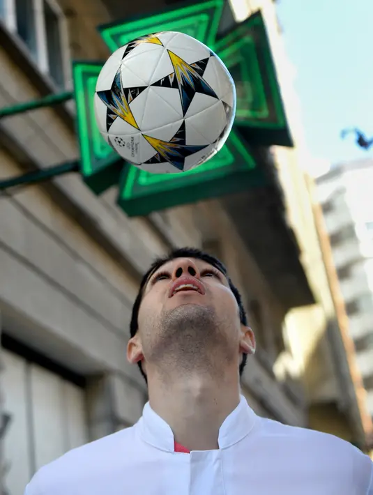 Pesepakbola asal Spanyol, Toni Dovale bermain bola di luar apotek keluarga tempatnya kini bekerja di Coruna, 26 Maret 2020. Lulusan sekolah farmasi berusia 29 tahun tersebut memutuskan untuk terjun langsung memerangi virus corona setelah  terperangkap di kampung halamannya. (MIGUEL RIOPA/AFP)