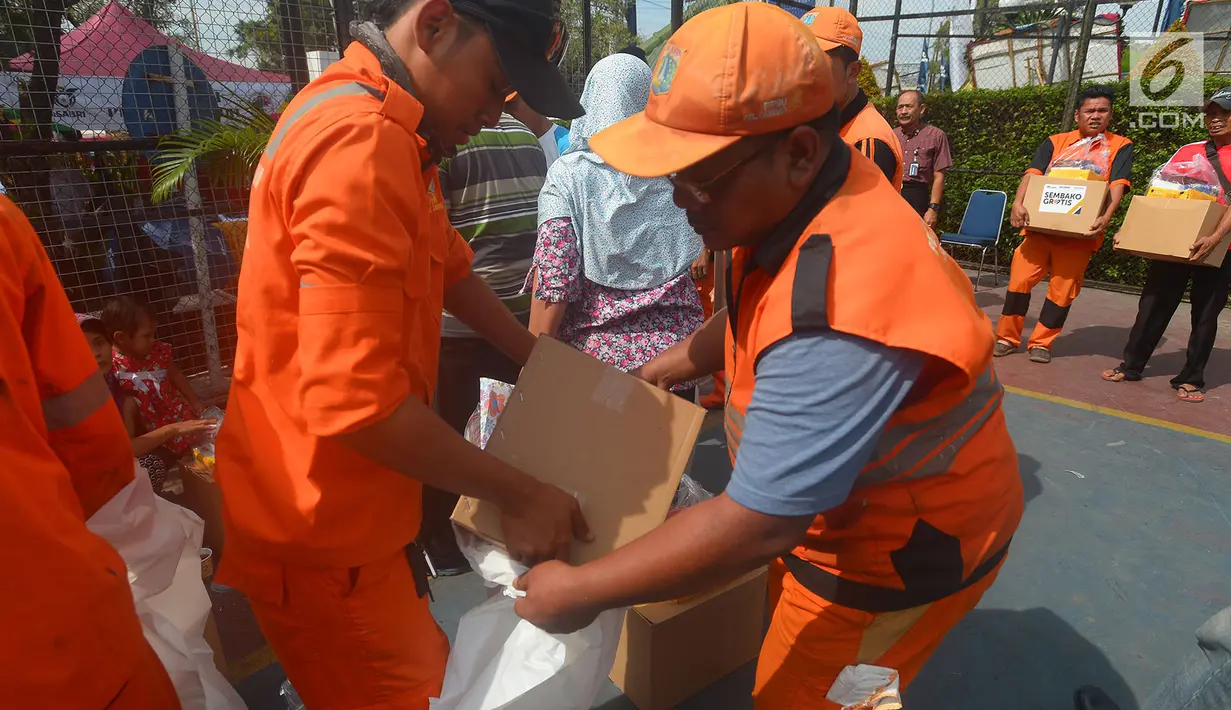Petugas Penangganan Prasarana dan Saran Umum (PSSU) atau pasukan oranye mendapatkan sembako gratis di Jakarta, Jumat (3/8). Pembagian sembako gratis tersebut dalam rangka menyambut HUT ASABRI ke-47 tahun. (Merdeka.com/Imam Buhori)