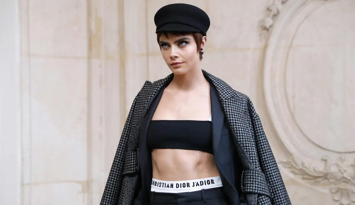 Aktris dan model Inggris Cara Delevingne berpose saat pemotretan sebelum tampil memperagakan busana koleksi fall/winter 2018 Christian Dior di Paris Fashion Week, Prancis (27/2). (AFP Photo/Patrick Kovarik)