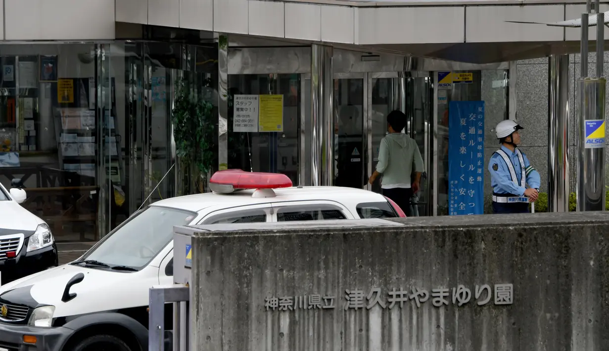Seorang polisi berjaga di luar lokasi serangan penusukan sarana difabel Tsuki Yamayuri-en di Sagamihara, barat Tokyo, Selasa (26/7). 19 orang tewas dalam serangan yang dilakukan seorang pria dengan menggunakan pisau. (Toshifumi Kitamura/AFP)