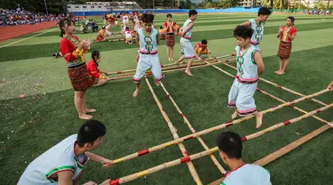 Para pelajar mengikuti kompetisi tari bambu di Sekolah Menengah Baoting yang berada di Wilayah Otonom Etnis Li dan Miao Baoting, Provinsi Hainan, China selatan, pada 18 November 2020. (Xinhua/Zhang Liyun)