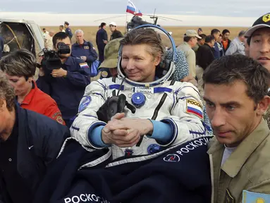 Petugas lapangan membawa kosmonot Rusia, Gennady Padalka usai mendarat di dekat kota Dzhezkazgan, Kazakhstan, Sabtu (12/9/2015). Padalka telah menorehkan 879 hari di luar angkasa dalam lima kali perjalanan. (REUTERS/Yuri Kochetkov/Pool)