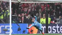 Kiper Real Madrid asal Belgia #01, Thibaut Courtois, menukik untuk merebut bola selama adu penalti setelah pertandingan leg kedua babak 16 besar Liga Champions UEFA antara Club Atletico de Madrid dan Real Madrid CF di stadion Metropolitano di Madrid, Kamis dini hari WIB (13-3-2025). (Thomas COEX/AFP)