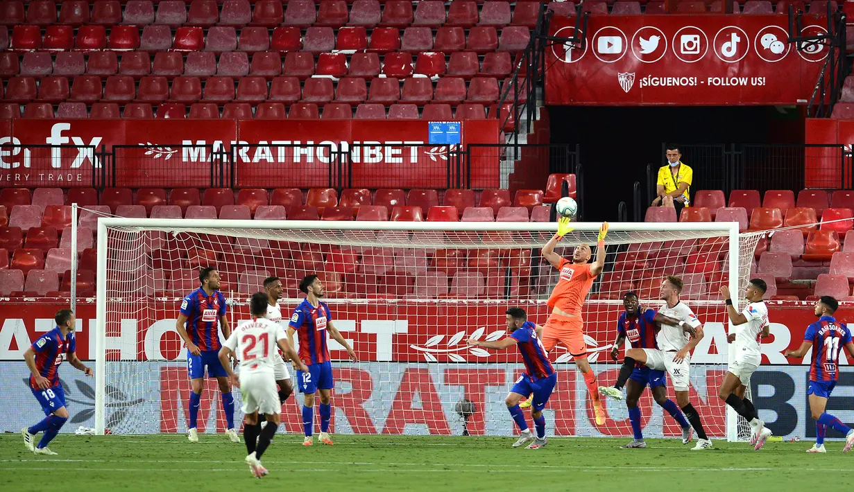 Kiper Eibar, Marko Dmitrovic, berusaha menangkap bola saat menghadapi Sevilla pada laga lanjutan La Liga pekan ke-34 di Estadio Ramon Sanchez Pizjuan, Selasa (7/7/2020) dini hari WIB. Sevilla menang 1-0 atas Eibar. (AFP/Cristina Quicler)