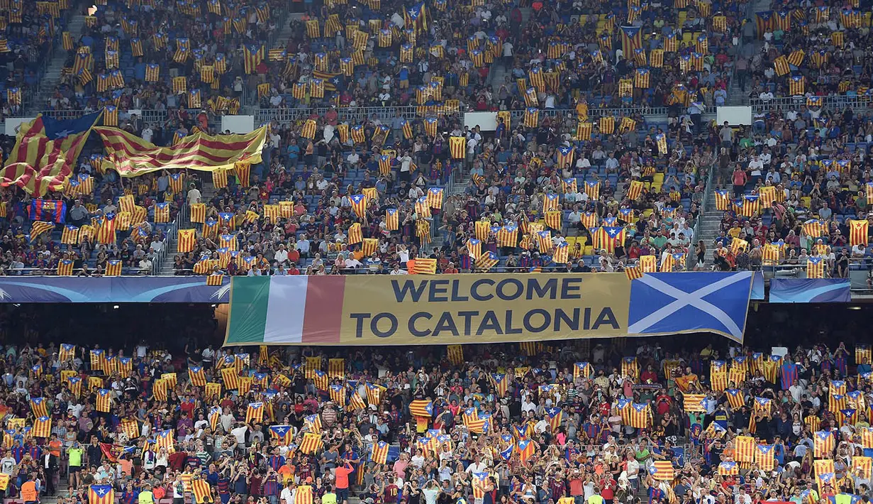 Para suporter mengibarkan bendera Esteladas saat laga Barcelona melawan Celtic. Pada laga Liga Champions selanjutnya El Blaugrana akan berhadapan dengan Monchengladbach. (AFP/Lluis Gene) 