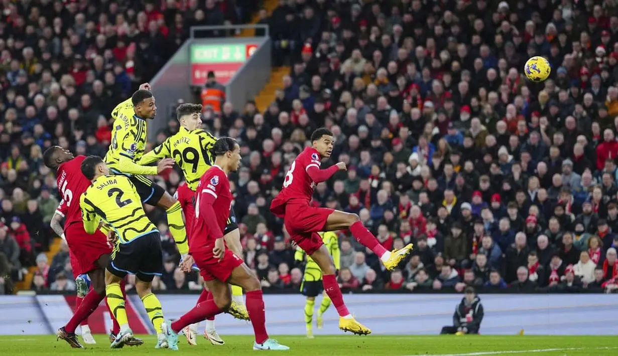 Pemain Arsenal, Gabriel Magalhaes, mencetak gol melalui tandukan kepala ke gawang Liverpool pada laga pekan ke-18 Premier League 2023/2024 di Stadion Anfield, Minggu (24/12/2023). Kedua tim bermain imbang 1-1. (AP Photo/Jon Super)