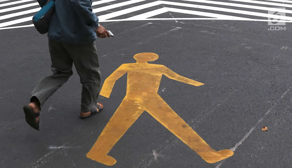 Warga menyeberangi pelican crossing di Halte Transjakarta Bank Indonesia (BI), Jakarta, Selasa (4/9). Pelican crossing diharap membuat warga memiliki kesempatan sama dalam menikmati layanan publik. (Liputan6.com/Immanuel Antonius)