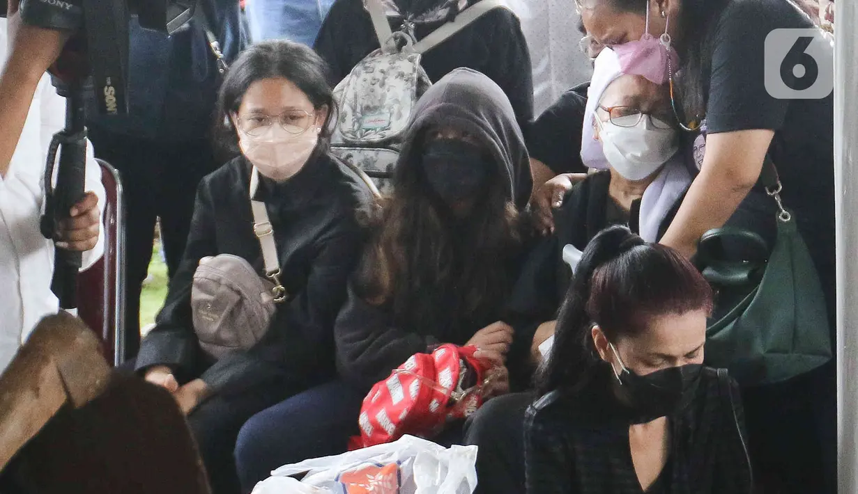 Anak musisi legendaris Bob Tutupoly memeluk sang ibu Rosmayasuto Nasution saat prosesi pemakaman di Tempat Pemakaman Umum (TPU) Tanah Kusir, Jakarta, Kamis (7/7/2022).  Bob Tutupoly meninggal dunia pada usia 82 tahun di Rumah Sakit Mayapada Jakarta, Selasa 5 Juni 2022 sekitar pukul 00.03 WIB. (Liputan6.com/Herman Zakharia)