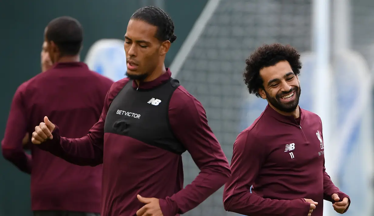 Gelandang Liverpool, Mohamed Salah (kanan) dan bek Virgil van Dijk (kiri) saat berlatih di kompleks pelatihan Melwood, Liverpool, Inggris, Senin (17/9). Liverpool akan menjamu Paris Saint-Germain (PSG) di Liga Champions 19 September 2018. (Paul ELLIS/AFP)