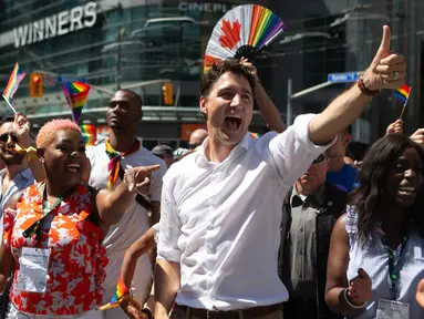 Perdana Menteri Kanada Justin Trudeau mengacungkan jempol saat mengikuti pawai LGBT Toronto's Pride Parade di Toronto, Kanada, Minggu (23/6/2019). Pawai digelar untuk mengenang peristiwa Stonewall yang terjadi di New York pada Juni 1969. (Chris Young/The Canadian Press via AP)