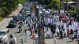 Sejumlah Massa berjalan ke arah menteng dari kuningan saat mengelar aksi, Jakarta, Senin (4/4). Dalam Aksinya tersebut mendesak agar di periksannya Gubernur Jakarta, Ahok terkait Korupsi Rs Sumber waras. (Liputan6.com/Helmi Afandi)
