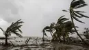 Orang-orang berjalan di pantai setelah lewatnya Badai Iota di Bilwi, Nikaragua (17/11/2020). Badai Iota telah menewaskan sedikitnya sembilan orang saat menghancurkan rumah, menumbangkan pohon dan menggenangi air. (AFP/Inti Ocon)