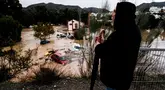 Seorang pria mengamati beberapa mobil yang tersapu air di kota Alora, Malaga, Spanyol, Selasa, 29 Oktober 2024. (AP Photo/Gregorio Marrero)
