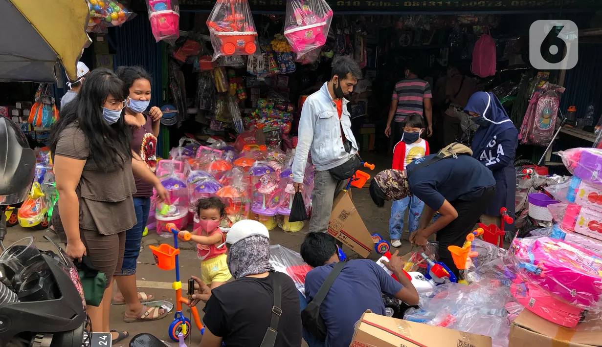 Warga memilih mainan tanpa menjaga jarak di Pasar Gembrong, Jakarta Timur, Minggu (31/5/2020). Meski penerapan masa Pembatasan Sosial Berskala Besar (PSBB) di Jakarta masih berlaku, namun pasar yang khusus menjual pernak-pernik mainan anak ini kembali dipadati warga. (Liputan6.com/Immanuel Antonius)