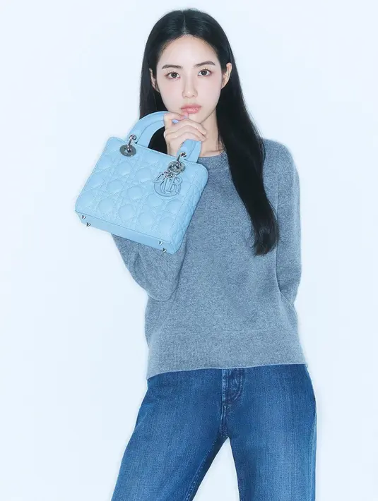 Hong Suzu tampil menawan dengan outfit kasual dan tas Diornya. Dalam foto ini, Hong Suzu menenteng Medium Lady Dior Bagi in Horizon Blue yang serasi dengan padu padan sweater abu-abu dan celana jeansnya. Foto: Document/Dior.