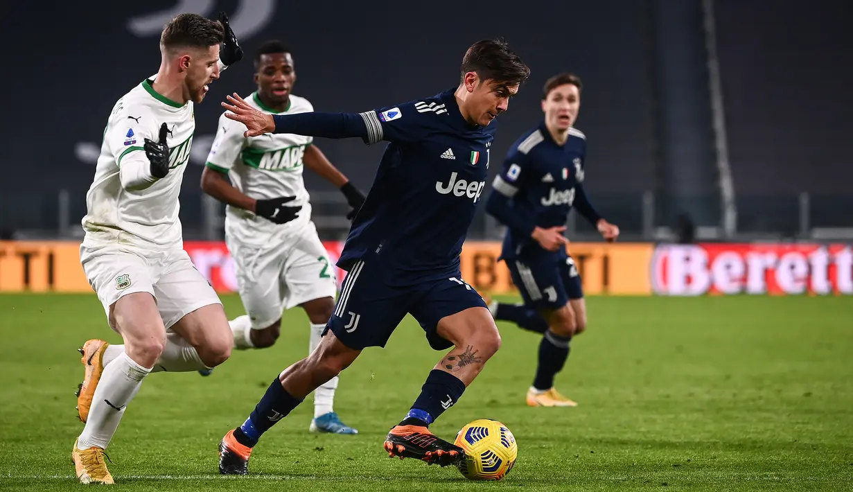 Striker Juventus, Paulo Dybala (kanan) menguasai bola dibayangi bek Sassuolo, Georgios Kyriakopoulos dalam laga lanjutan Liga Italia Serie A 2020/21 pekan ke-17 di Juventus Stadium, Minggu (10/1/2021). Juventus menang 3-1 atas Sassuolo. (AFP/Marco Bertorello)