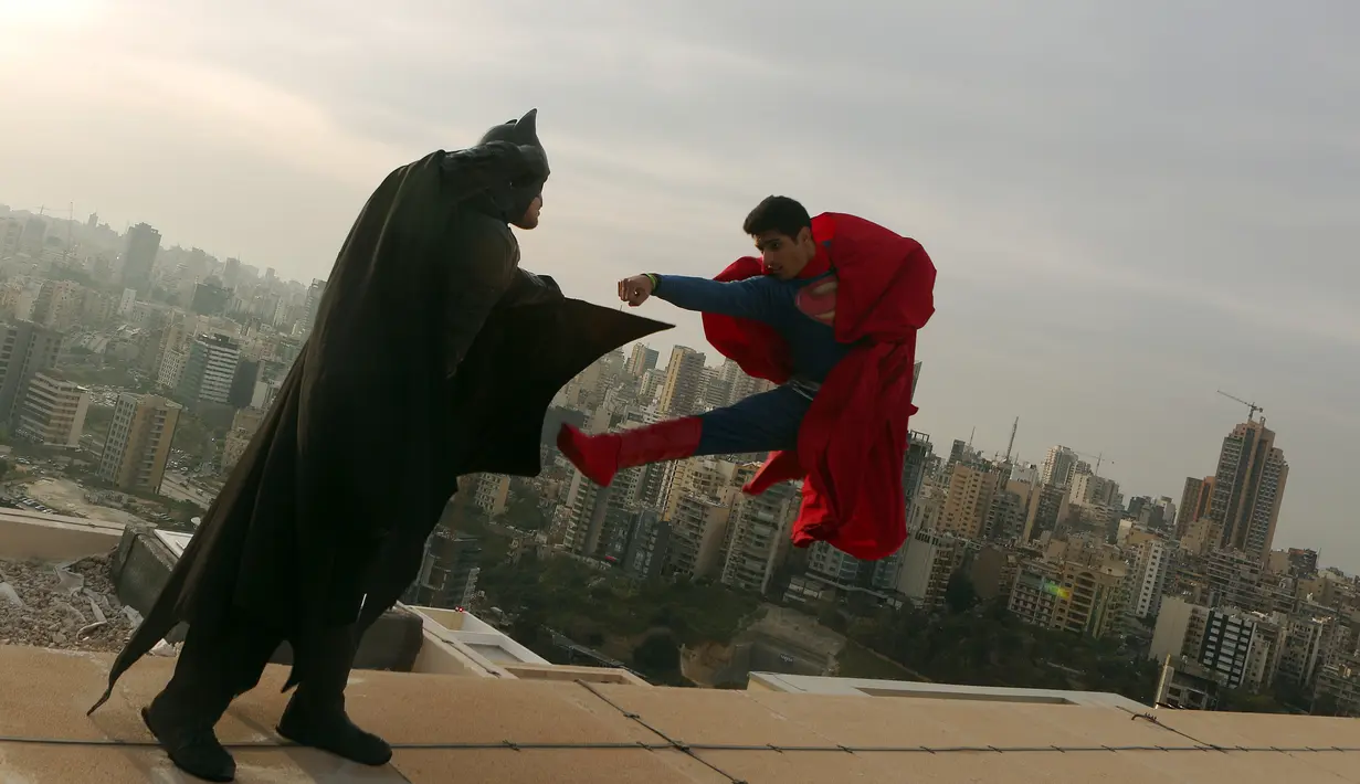 Dua orang pria mengenakan kostum Batman dan Superman melakukan adegan bertarung saat sesi pemotretan di Lebanon (23/3). Film terbaru dari Batman vs Superman telah ditayangkan dibeberapa bioskop dunia. (PATRICK BAZ / AFP)