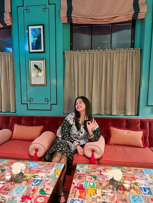 Singgah di sebuah sofa cantik, Raline Shah menunjukkan dirinya benar-benar menikmati liburan. Ia mengenakan long shirt dress dipadukan dengan tank top. Perpaduan motif mint dan hitam pada outfit Raline Shah membuatnya tampil ceria (instagram/ralineshah)