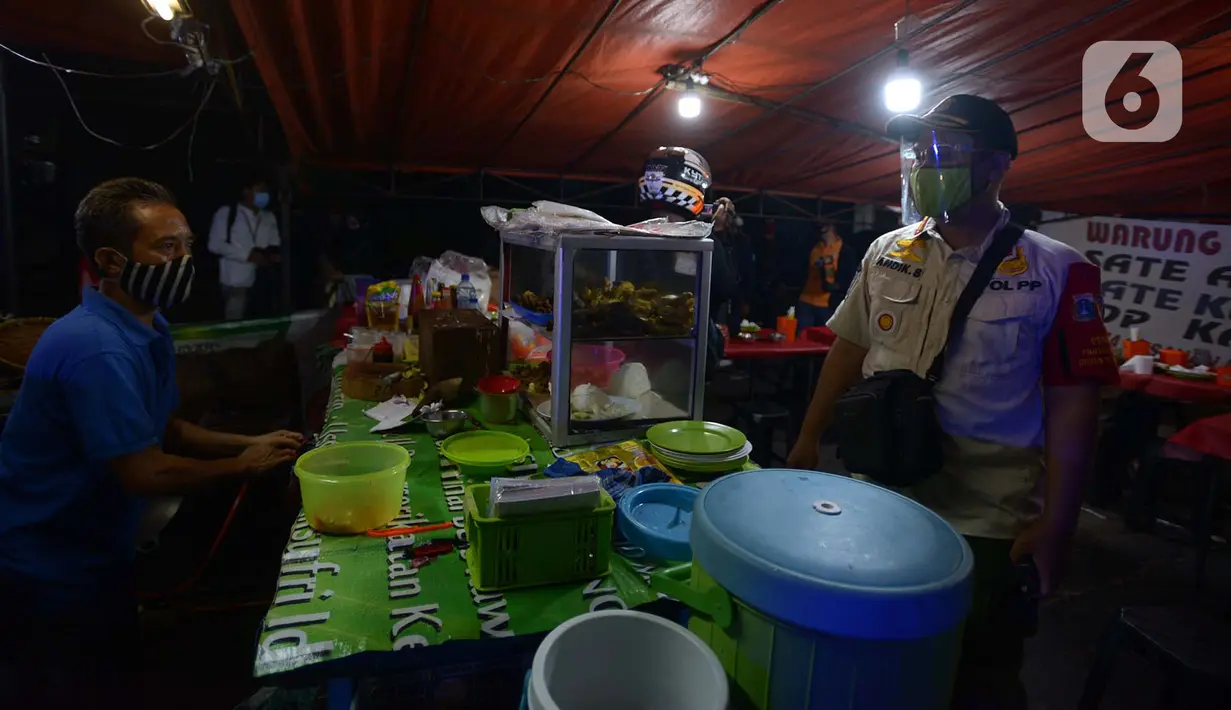 Petugas Satpol PP melakukan penertiban penerapan PSBB tempat makan yang masih menyediakan tempat konsumen di wilayah Kecamatan Pulogadung, Jakarta, Jumat (18/9/2020). Malam, Razia dilakukan memastikan ketidakadaannya konsumen makan ditempat tersebut. (merdeka.com/Imam Buhori)