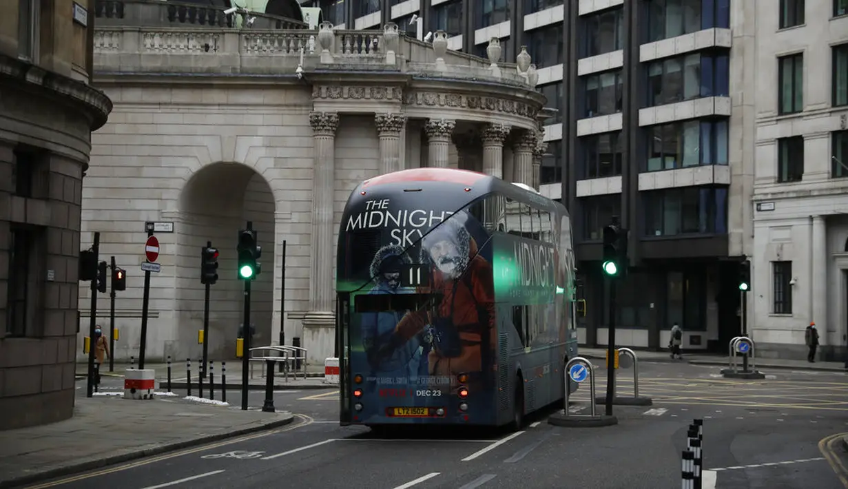 Sebuah bus melewati distrik keuangan pada pagi pertama penerapan lockdown nasional ketiga di Kota London, Inggris, 5 Januari 2021. Inggris menerapkan lockdown nasional ketiga untuk membendung lonjakan infeksi COVID-19 yang mengancam rumah sakit. (AP Photo/Matt Dunham)