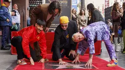 Personel Red Hot Chili Peppers, Anthony Kiedis, Flea, John Frusciante dan Chad Smith berpose saat merayakan dalam upacara peresmian band tersebut yang mendapatkan bintang di Hollywood Walk of Fame, Los Angeles, California, Kamis (31/3/2022). (Willy Sanjuan/Invision/AP)