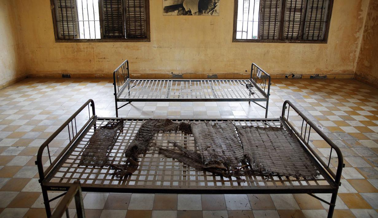 Sebuah foto terpajang di dinding ruangan yang pernah menjadi tempat penyiksaan di bekas penjara Khmer Merah Tuol Sleng, Phnom Penh, (5/8/2014). (REUTERS/Damir Sagolj)