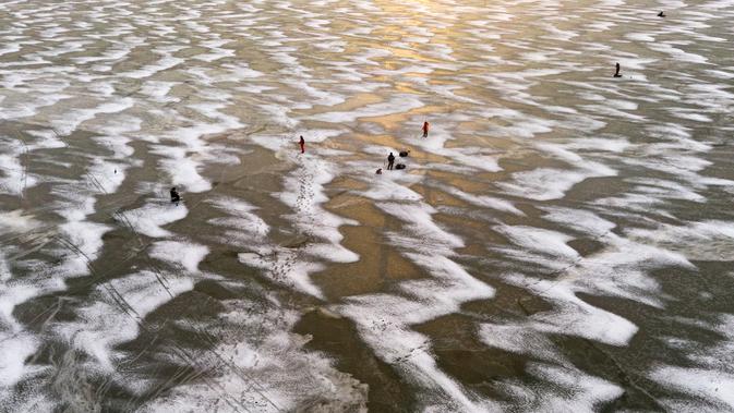 Pandangan udara menunjukkan para pria sedang memancing di tengah Laut Bothnia yang membeku di dekat Vaasa, Finlandia, 28 Desember 2018. Memancing di laut beku merupakan hal yang ditunggu-tunggu oleh sebagian warga setempat. (OLIVIER MORIN / AFP)
