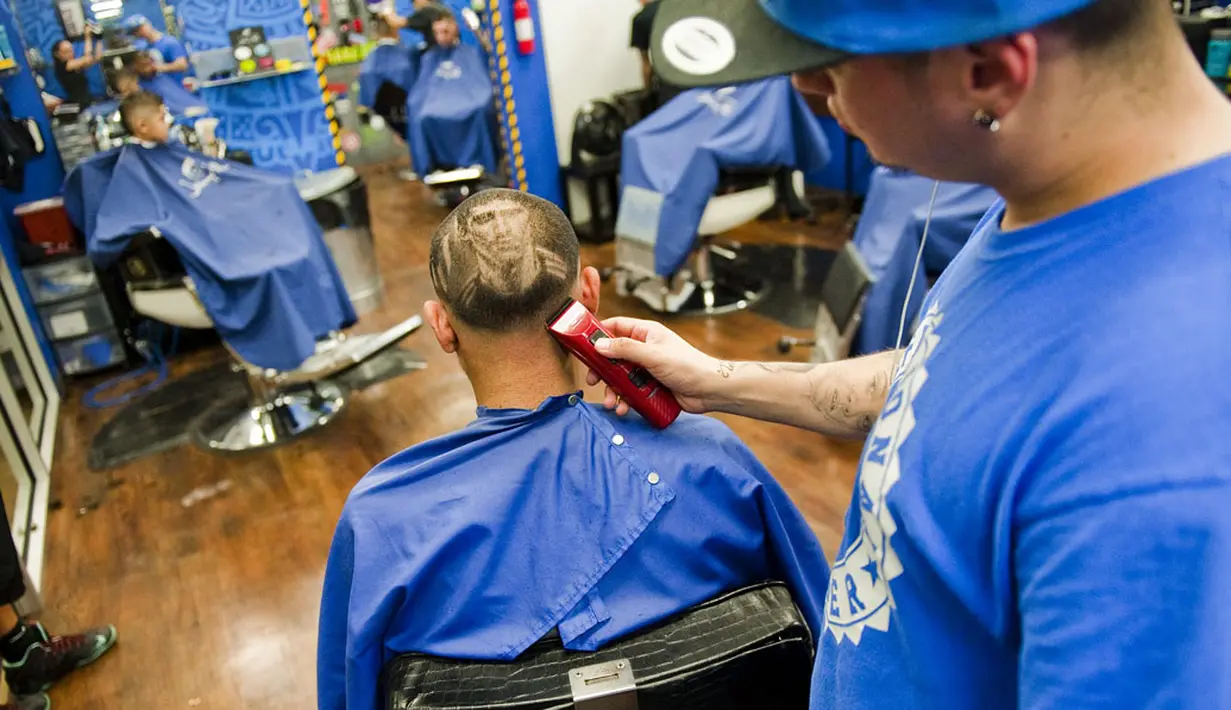 Pemilik salon 'Rob the Original', Rob Ferrel, menyelesaikan ukiran wajah Lionel Messi pada rambut pelanggannya, jelang laga 16 besar Piala Dunia 2014 antara Argentina vs Swiss, di San Antonio, Texas, (30/6/2014). (REUTERS/Ashley Landis)